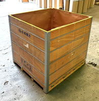Wooden shipping crate with metal frame on a concrete floor